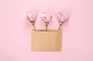 Sevgililer Günü, Uluslararası Kadınlar Günü ya da Anneler Günü için moda tek renkli pankart. Parti ya da düğün davetiyesi. Çiçekli üç Eustoma çiçeği aranjmanı ve pembe arka planda boş bir kart.