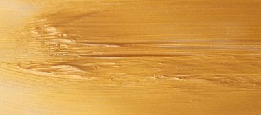 Altın ya da altın renkli akrilik boya arka planda yakın plan. Üst görünüm, alanı kopyala.