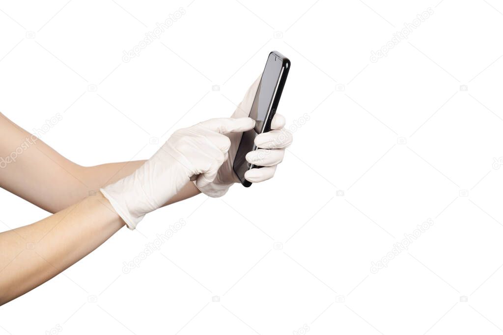 Young woman holding a mobile phone in her hands wearing disposable latex protective gloves isolated on white. Coronavirus spreading precautions measures concept. Copy space