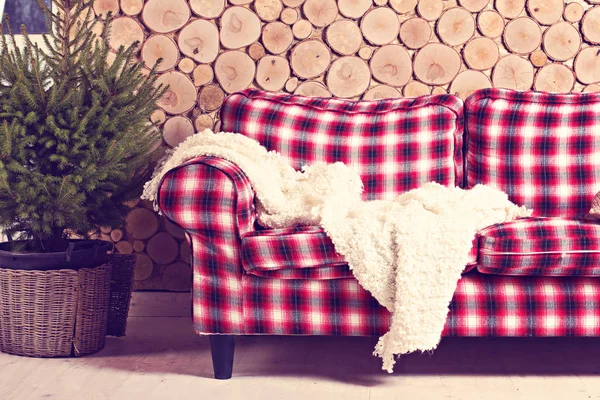 Checkered sofa, kratę, drzewa, drewniane ściany — Zdjęcie stockowe
