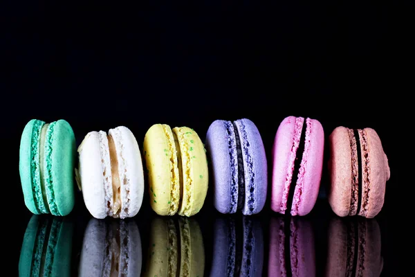 Multicolored macaroons a black — Stock Photo, Image