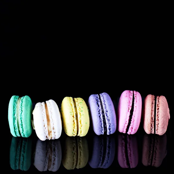 Multicolored macaroons a black — Stock Photo, Image