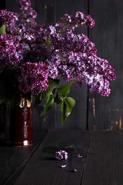 Λιλά λουλούδια σε σκούρο φόντο ξύλινη — Φωτογραφία Αρχείου