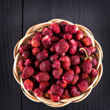 Karanlık bir arka plan üzerinde yaban çileği çilek.