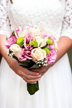 Kadın elinde bir gelin buketi.