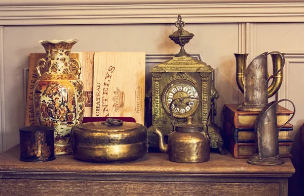 Στο στήθος των συρταριών, ένα σύνταγμα με αρχαία πράγματα. Αρχαία ρολόι, ένα βάζο. — Φωτογραφία Αρχείου