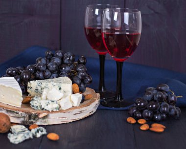 Kırmızı şarap ve aperatifler. Şarap, üzüm, peynir, fındık, zeytin. Romantik akşam, Natürmort.