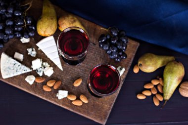 Kırmızı şarap ve aperatifler. Şarap, üzüm, peynir, fındık, zeytin. Romantik akşam, Natürmort.