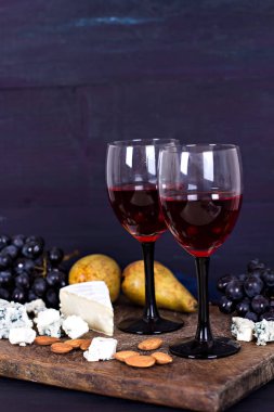 Kırmızı şarap ve aperatifler. Şarap, üzüm, peynir, fındık, zeytin. Romantik akşam, Natürmort.