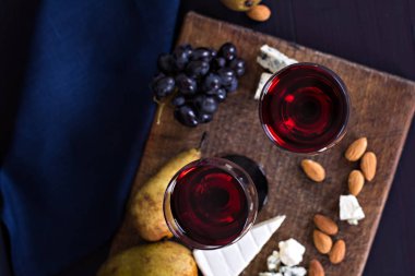 Kırmızı şarap ve aperatifler. Şarap, üzüm, peynir, fındık, zeytin. Romantik akşam, Natürmort.