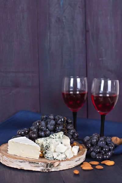 Vino rosso e snack. Vino, uva, formaggio, noci, olive. Serata romantica, natura morta . — Foto Stock