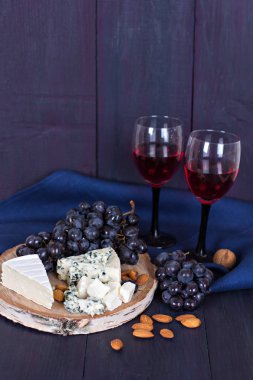 Kırmızı şarap ve aperatifler. Şarap, üzüm, peynir, fındık, zeytin. Romantik akşam, Natürmort.