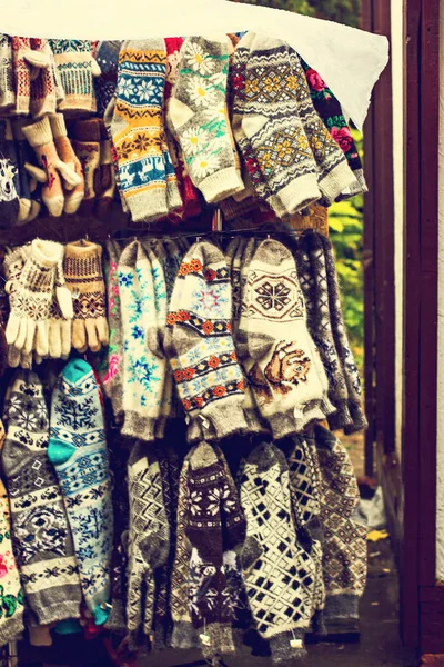 Gestrickte Handschuhe und Socken mit bunten Ornamenten zum Verkauf auf dem Markt — Stockfoto