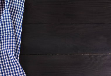 Koyu ahşap zemin üzerine mavi mutfak havlusu. Menüsü, metin, yer tarifi.