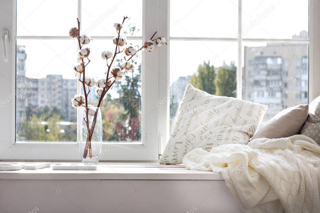 cushions and a knitted plaid on the windowsill. 