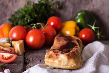 Ev yapımı tavuk, peynir ve eski bir ahşap masa üzerinde beyaz soslu sebze meyveli turta. Rustik tarzı.