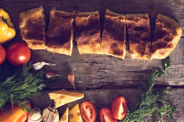 Ev yapımı tavuk, peynir ve eski bir ahşap masa üzerinde beyaz soslu sebze meyveli turta. Rustik tarzı.