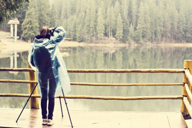 Bir kız fotoğrafçı bir tripod fotoğraf alır 