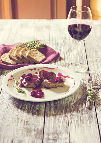 Kött med en söt sås och ett glas rött vin. — Stockfoto