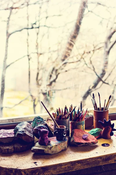 Paint jars and various brushes in big wooden holder. — Stock Photo, Image