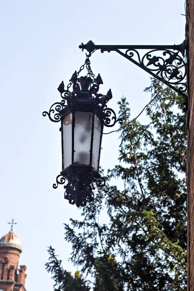 Un'antica lanterna in ferro battuto su un edificio in una strada di una città europea . — Foto Stock
