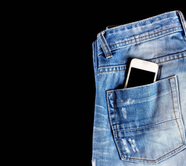 Mavi, aşınmış kot pantolon ve arka cebinde bir telefon 