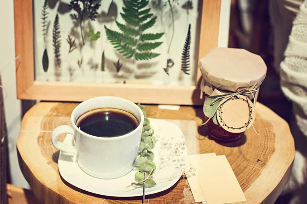 Een kopje koffie en een foto met gedroogde bladeren, een herbarium. — Stockfoto