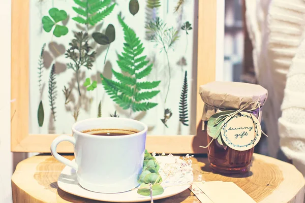Een kopje koffie en een foto met gedroogde bladeren, een herbarium. — Stockfoto