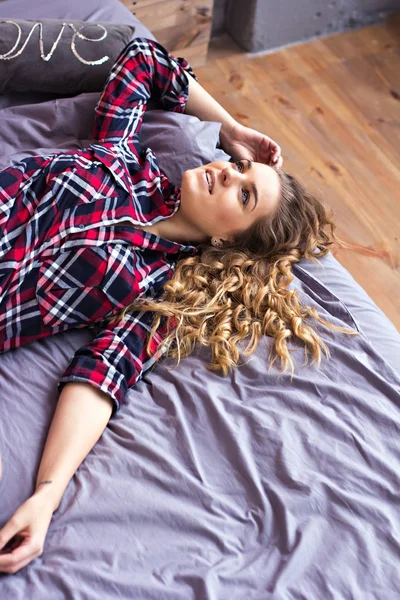 Mooie blondie meisje in bed. In het geruite shirt — Stockfoto