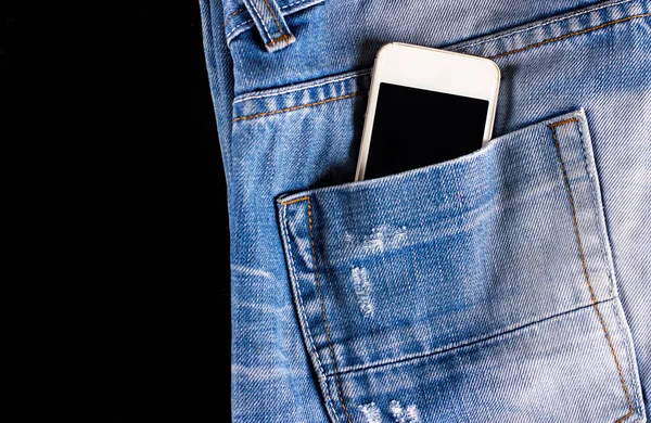 Blue, worn jeans and a phone in the back pocket — Stock Photo, Image