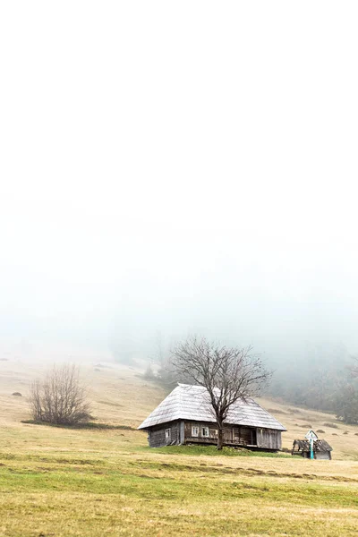 Paisagem montanhosa no nevoeiro. casa nas montanhas. Montanhas Cárpatas . — Fotografia de Stock