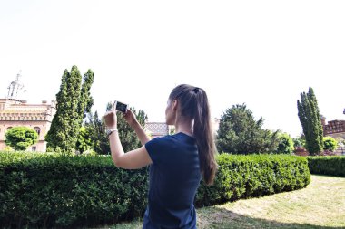 Bir kız bir fotoğraf tarihi bir binada bir cep telefonunda yapıyor.