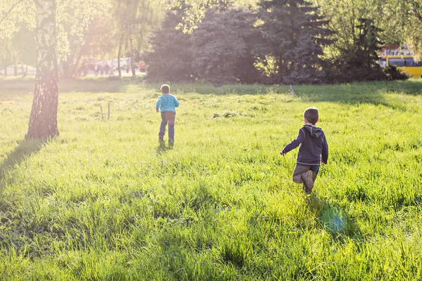 Two boys are running around in the park. — Stock Photo, Image