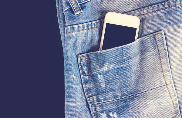 Blue, worn jeans and a phone in the back pocket — Stock Photo, Image