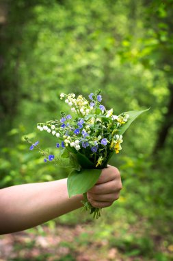  Vadideki zambak ve orman Menekşe bir kadının elinde bir buket.