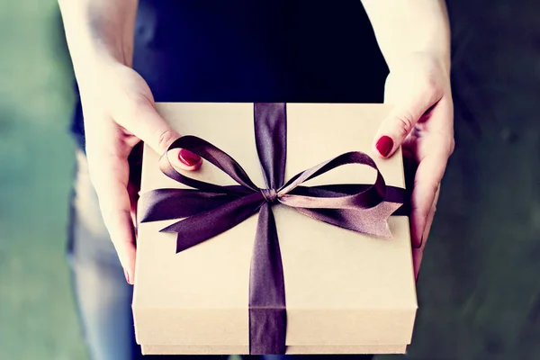 Female hands hold a crafted box with a gift. — Stock Photo, Image