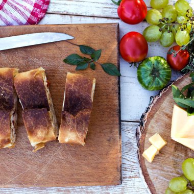 Peynir ve kurutulmuş domates ile meyveli turta. Akşam yemeği için sofrayı. Öğle Yemeği. Ev yapımı pasta, turta ve aperatifler, sebze, meyve, peynir.