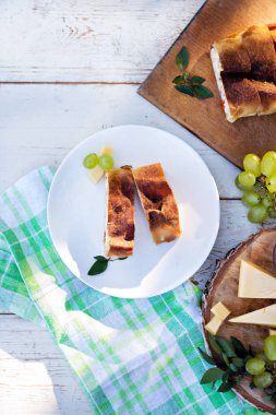 Peynir ve kurutulmuş domates ile meyveli turta. Akşam yemeği için sofrayı. Öğle Yemeği. Ev yapımı pasta, turta ve aperatifler, sebze, meyve, peynir.