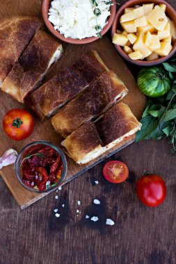 Peynir ve kurutulmuş domates ile meyveli turta. Akşam yemeği için sofrayı. Öğle Yemeği. Ev yapımı pasta, turta ve aperatifler, sebze, meyve, peynir.