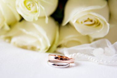 Evlilik yüzükleri, duvak, beyaz güller, düğün aksesuarları.