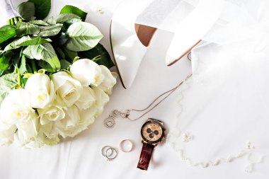 Evlilik yüzükleri, duvak, beyaz güller, düğün aksesuarları.