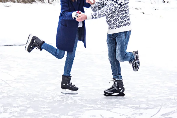 loving couple in warm sweaters skates on a frozen lake