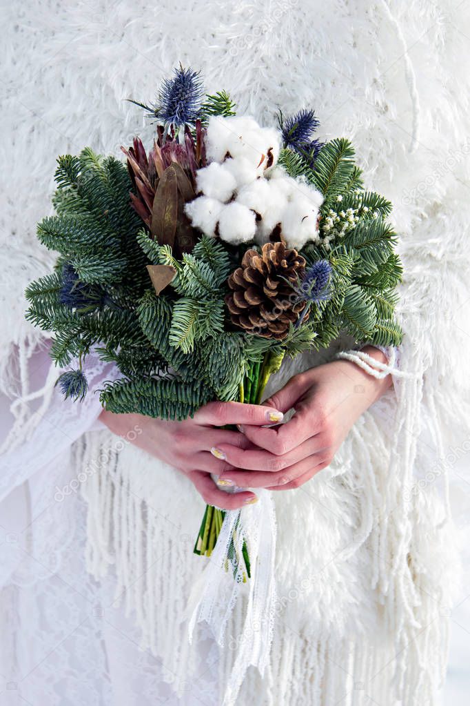 Winter bouquet of the bride. Fir branches, cotton flowers in a bride's bouquet