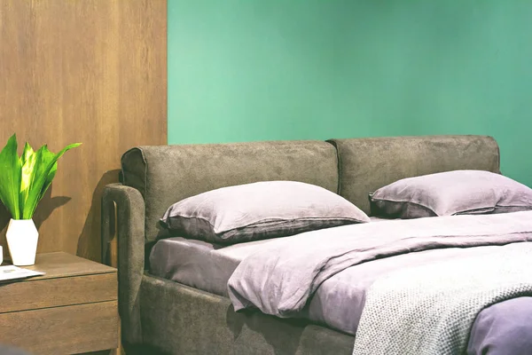 Güzel, minimalist bir iç mekânda mor bir yatak. — Stok fotoğraf