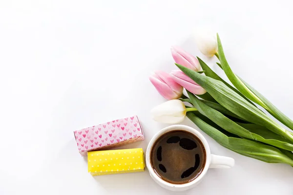 Um buquê de tulipas, uma xícara de café expresso e uma pequena caixa com um presente. surpresa, um presente para as férias das mulheres, 8 de março — Fotografia de Stock