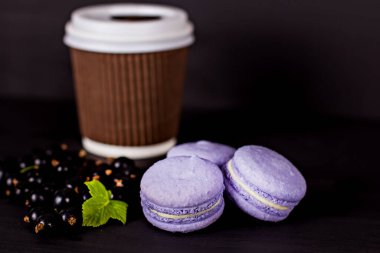 Macarons tanımlama karanlık bir arka plan üzerinde. Boş alan, seçici odak içeren koyu arka plan üzerinde renkli acıbadem kurabiyesi kurabiye ve tatlı kule