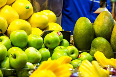Piyasadaki meyveler, mangolar, elmalar, limonlar, narlar. Satılık taze meyve suyu. Meyve suyu konsepti. Taze egzotik meyve duvarları Taze Nar Suyu Çiftçi Marketi 'nde