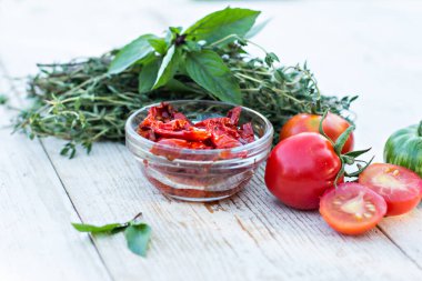 Kurutulmuş güneş domatesleri ve aromatik otlar - kekik, fesleğen, biberiye. Güneşte kurutulmuş domates, bitki ve deniz tuzu, cam kavanozda zeytinyağı.