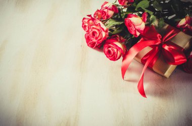 Kırmızı gül buketi ve ahşap masa hediye.