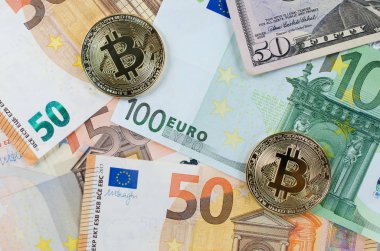Euro banknot üzerinde iki altın bitcoins.